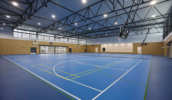 Photo inside the Sports Centre for Excellence showing the flooring with court outlines and the high ceiling.