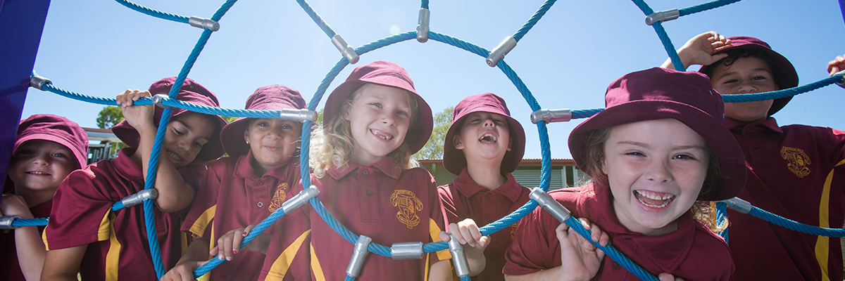 Students on a playground smiling at the camera